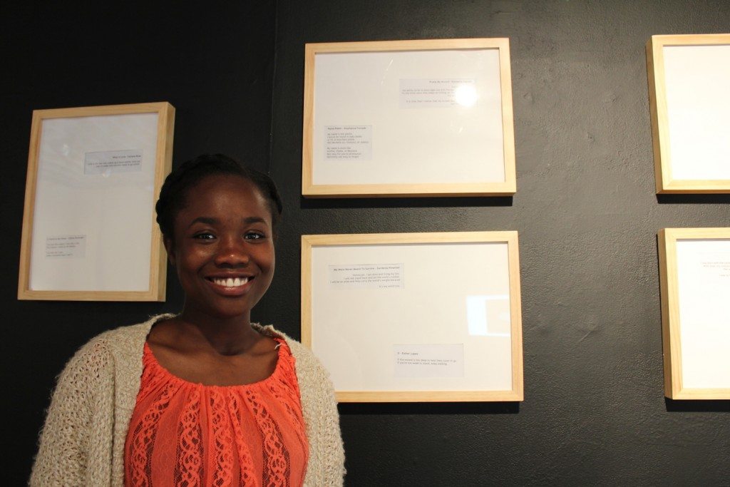 Kimberly Cajuste standing next to her poem "Praise my Accent."